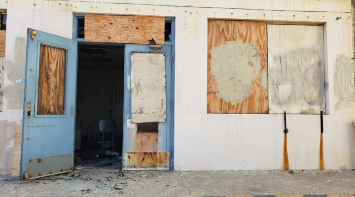 a run down building with boarded up doors